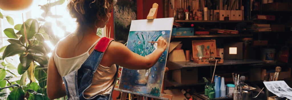 A woman sitting in a studio, painting, indicating a way of finding your passion