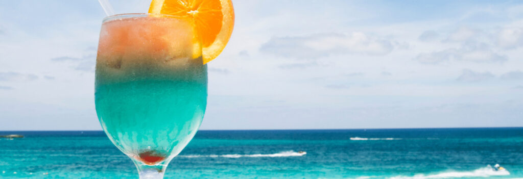 A colorful drink on a beach, hinting that relaxation is why vacation is important