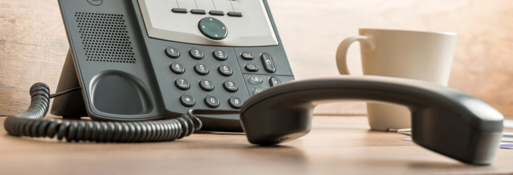 A business phone, left of the hook during internal communications