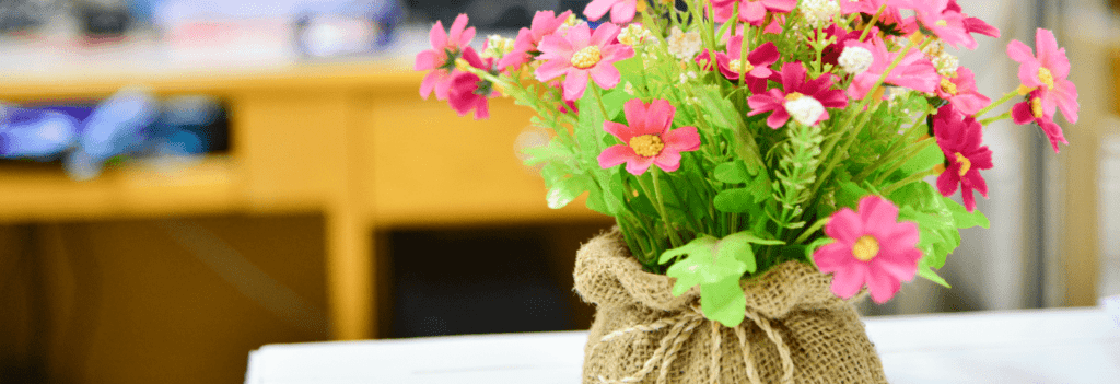 Flowers sitting on top of a desk as part of several office layout ideas