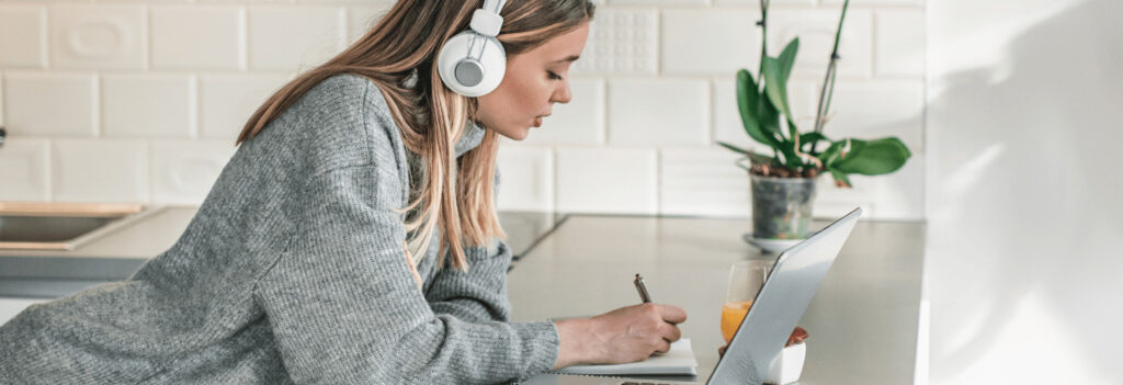 A young woman listening to an online course in her house