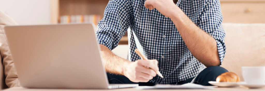 A man writing on paper, working to improve his copywriting skills